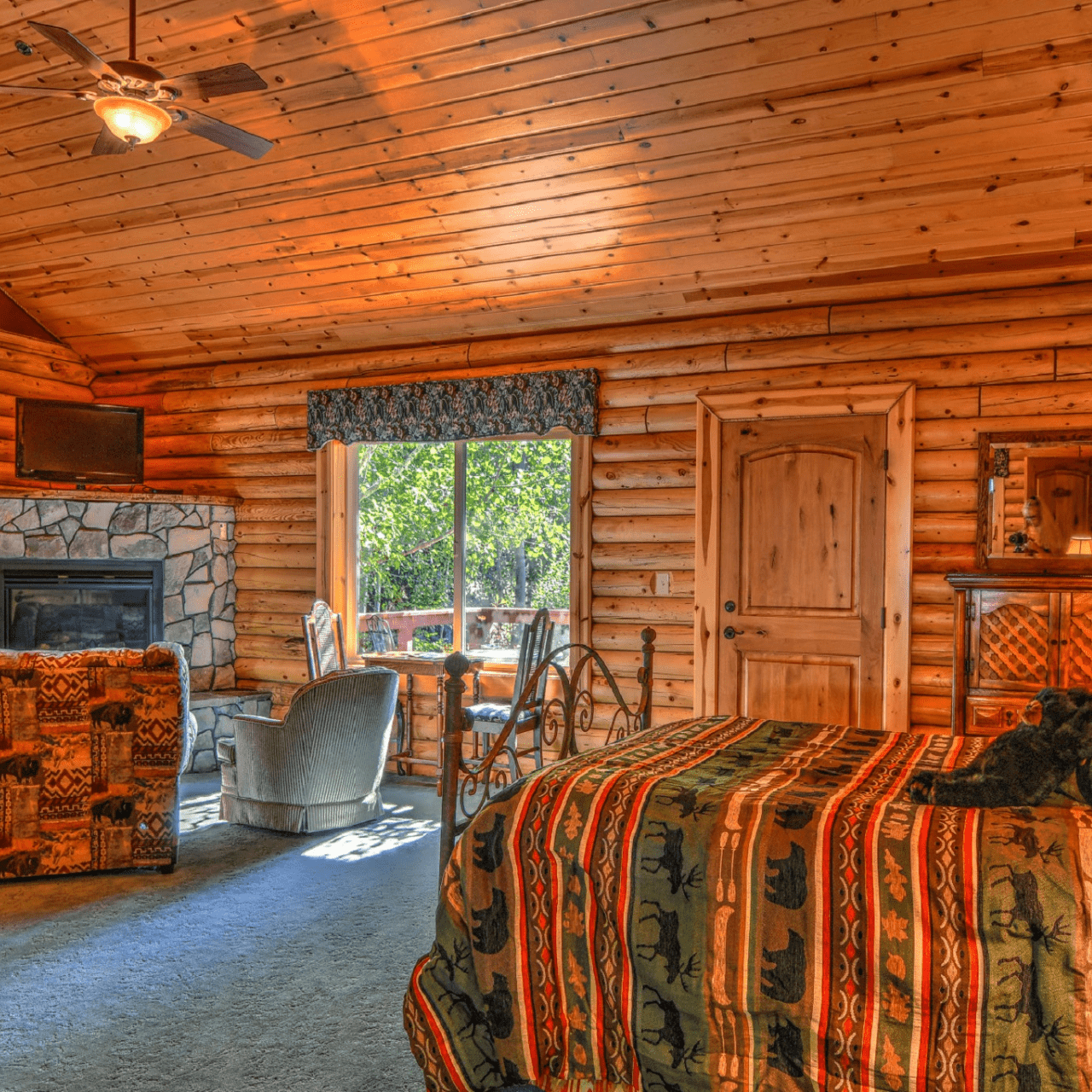 Image of queen bed with stuff bear and gas corner fireplace in luxurious suite in Swan Valley Idaho